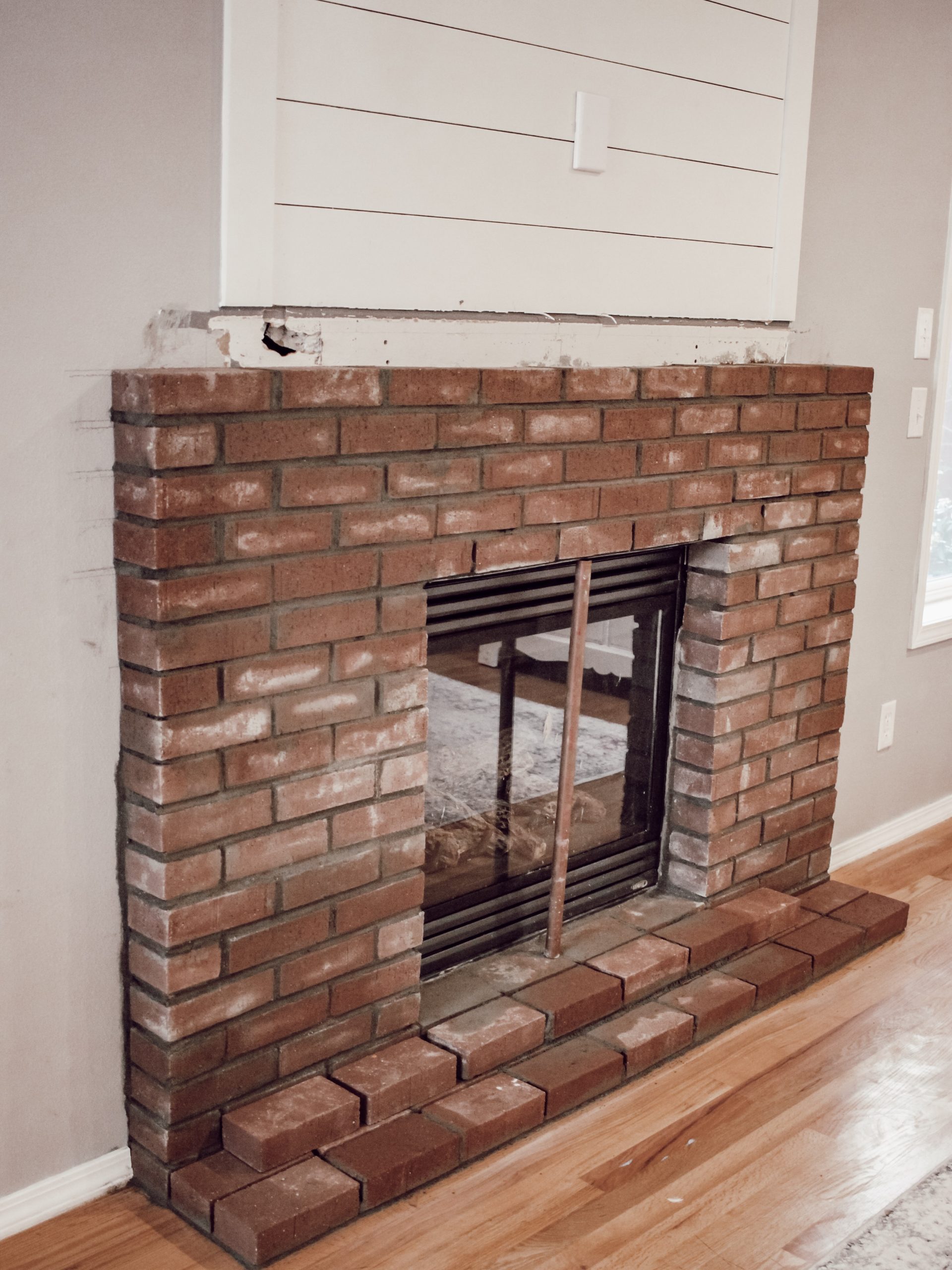 How to Build a DIY Brick Fireplace Hearth with a Shiplap Accent Wall